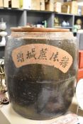 A large Chinese glazed terracotta sugar storage container with wood lid.