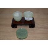 Two Chinese jade Mijiu cups and lidded trinket box with hardwood stand