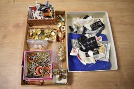 A box of assorted costume jewellery, enamelled and embroidered badges, plus military buttons,