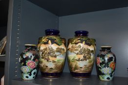 A pair of Japanese Satsuma urn shaped vases, having enamelled decoration against a blue ground,