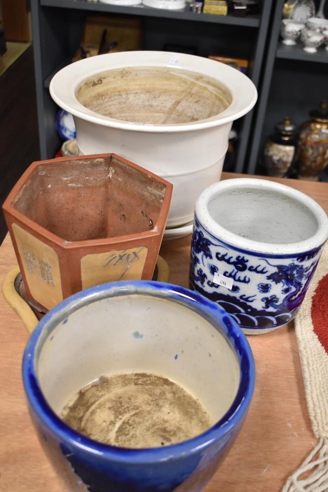 Four planters, including one with blue and white Japanese styled dragon decoration.