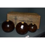 Three early 20th Century turned wood lawn bowls, of graduating sizes, in a Thomas Taylor of