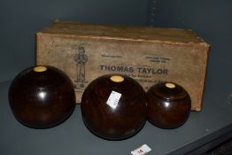 Three early 20th Century turned wood lawn bowls, of graduating sizes, in a Thomas Taylor of