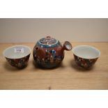 A Japanese glazed pottery teapot, decorated with traditional figures, measuring 11cm tall,