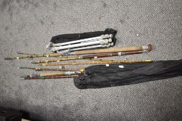 A collection of split cane fishing rods together with a camera tripod stand
