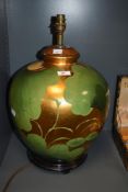 A 20th Century Chinese gold/gilt lustre lamp base, of spherical form, and raised on a hardwood