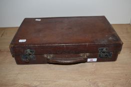 A vintage leather brief case, having internal compartments.