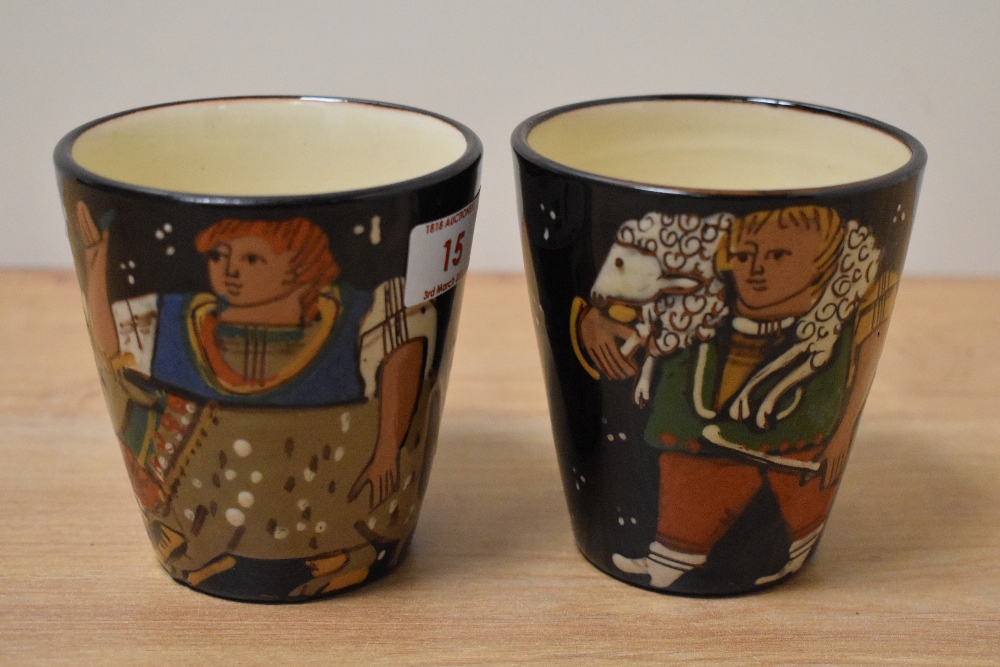 A pair of early 20th Century studio pottery treacle glazed beakers, of Continental style, with