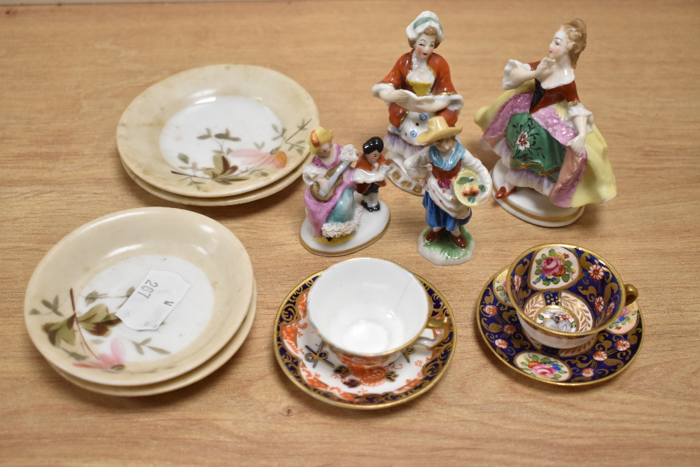 A miniature Royal Crown Derby cup and saucer and similar example, four whimsical figurines and