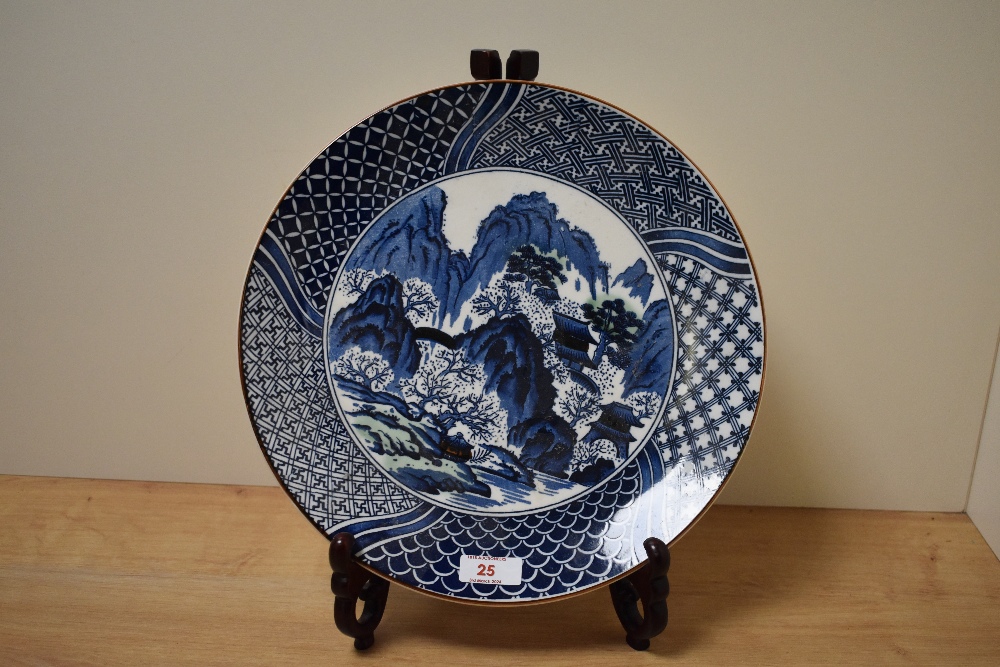 A 20th Century Japanese blue and white charger, transfer printed with a traditional pagoda design,