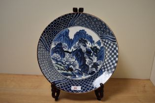 A 20th Century Japanese blue and white charger, transfer printed with a traditional pagoda design,