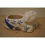 A 20th Century glazed pottery blue and white planter, in the form of a reclining figure, and stamped