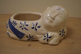 A 20th Century glazed pottery blue and white planter, in the form of a reclining figure, and stamped