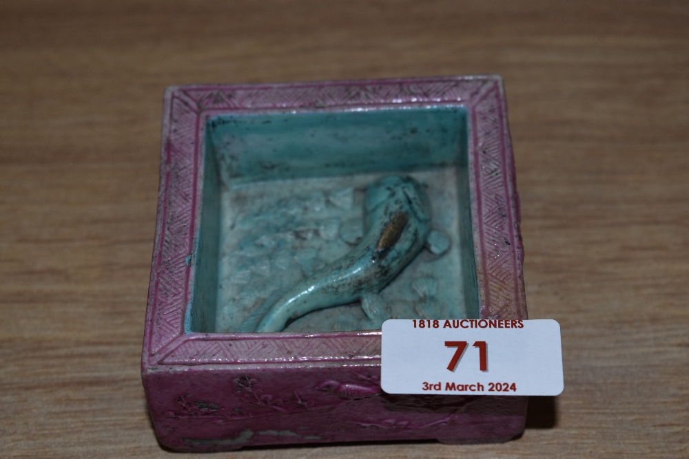 An Oriental square ceramic ashtray or trinket pot, having pink and blue ground with raised Koi