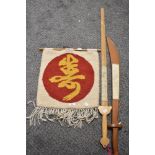 Two wooden swords, with oriental writing to 'blades' and a wool wall hanging.