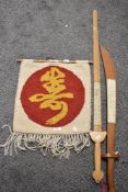 Two wooden swords, with oriental writing to 'blades' and a wool wall hanging.