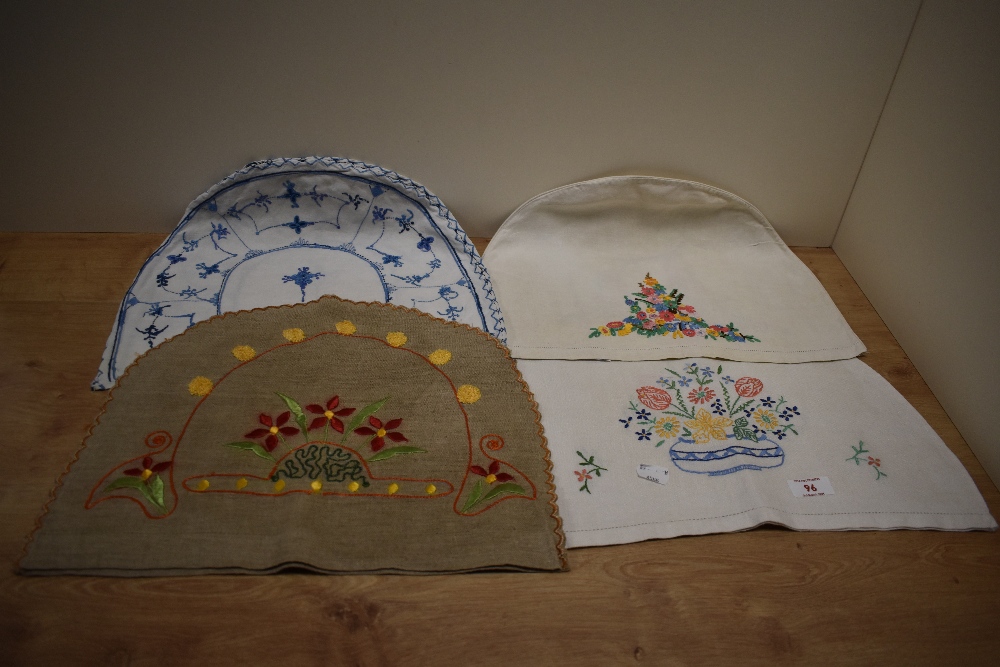 Three 1930s embroidered tea cosies, the largest measures 40cm long