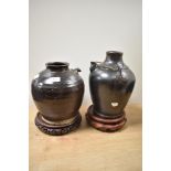 Two glazed earthenware spouted receptacles, one having handle, both with treacle glaze and sat on