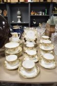 A selection of Noritake table ware, having white ground with gilt relief floral baskets and motifs.