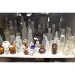 A large collection of vintage glass bottles and jars , including advertising bottles of interest