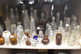A large collection of vintage glass bottles and jars , including advertising bottles of interest