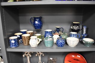 A collection of Wetheriggs Pottery, Penrith, jugs, bowls, condiment pots and mugs, having swirled
