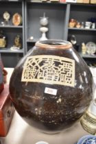 A large glazed earthenware floor vase, having black glaze with oriental style motif.