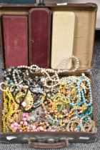 A vintage suitcase containing an assortment of vintage beaded costume jewellery, including Simulated