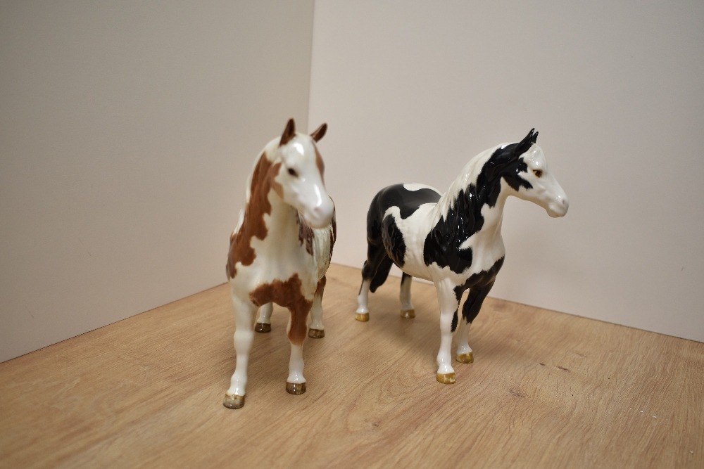 Two Beswick Pottery Pinto Ponies, comprising Skewbald first version and Piebald second version,