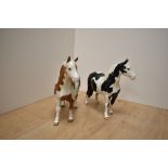 Two Beswick Pottery Pinto Ponies, comprising Skewbald first version and Piebald second version,