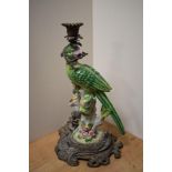 An attractive cast gilt metal and porcelain candlestick, formed as a perched parrot holding a