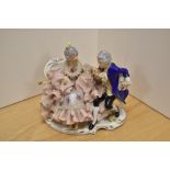 A Dresden porcelain figure group, depicting a Man and Woman reclining on a chaise longue, having