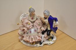 A Dresden porcelain figure group, depicting a Man and Woman reclining on a chaise longue, having