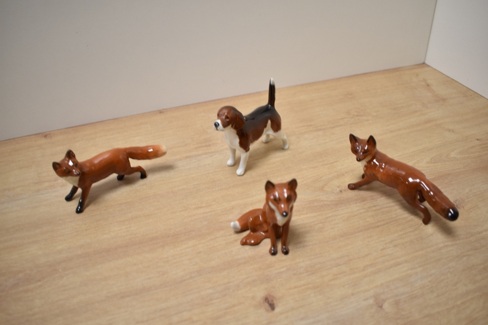 A group of three Beswick Pottery fox studies, comprising two fox standing number 1440 designed by