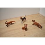 A group of three Beswick Pottery fox studies, comprising two fox standing number 1440 designed by