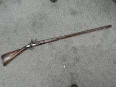 A single barrel flintlock Musket, ram rod, proof mark V, plain wood stock, decorated brass side
