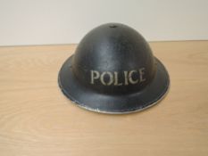A WWII period Police Steel Helmet in dark blue with white lettering, complete with liner and chin
