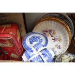 Three decorative wall plates showing country scenes, two large meat platters, a willow pattern