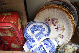 Three decorative wall plates showing country scenes, two large meat platters, a willow pattern