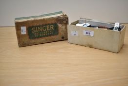A vintage Singer buttonhole attachment in original box.