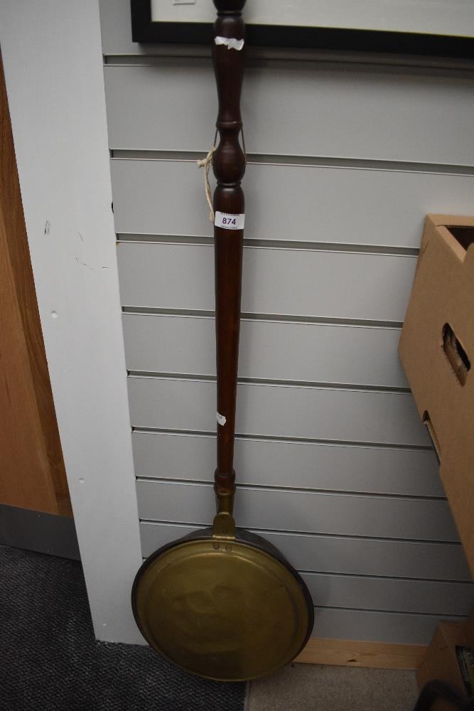 A traditional copper and brass warming pan having mahogany handle