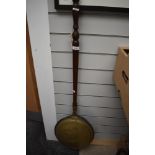 A traditional copper and brass warming pan having mahogany handle