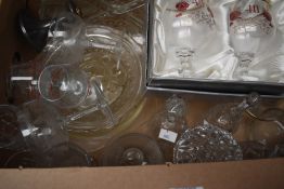 A collection of assorted glass items including cake plate, decorative bells, bonbon dishes, vases