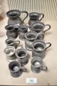 A group of twelve pewter measures, of baluster or tankard form and each stamped with measurement