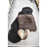 A double sized black sheep skin rug 180cm x 67cm sold along with a large sheep skin fleece cushion