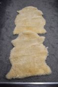 Two small sheepskin rugs, 80cm approximately