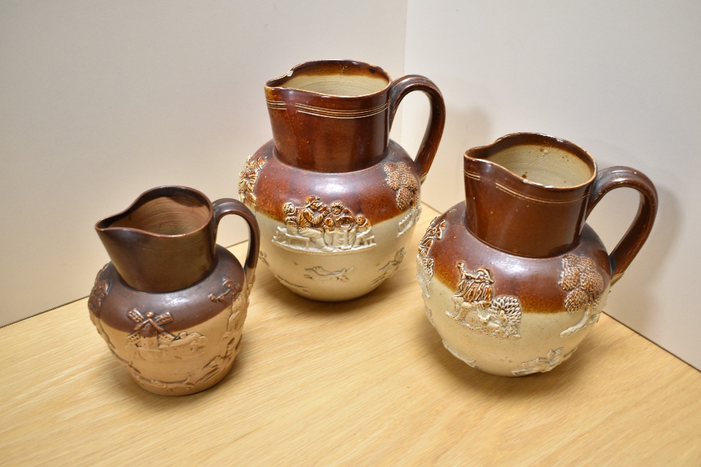 A group of three 19th century stoneware hunting jugs, half buff glazed and applied relief moulded