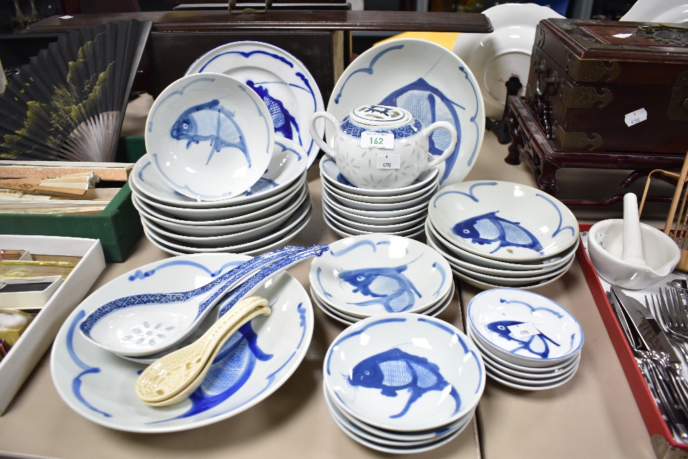 A group of 20th century Chinese blue and white pottery bowls and dishes, each decorated with koi