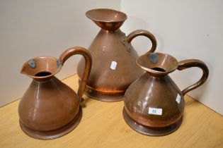 Three 19th Century planished copper measures, of graduating sizes, the largest measures 26cm tall