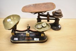 A set of Berry & Warmington painted cast-iron and brass scales with four brass weights, and sold
